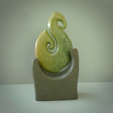 Hand carved New Zealand Flower Jade Hook with Greywacke stand sculpture. Hand carved in New Zealand by Ric Moor. This is a one only sculpture and is a beautiful, large, display piece.