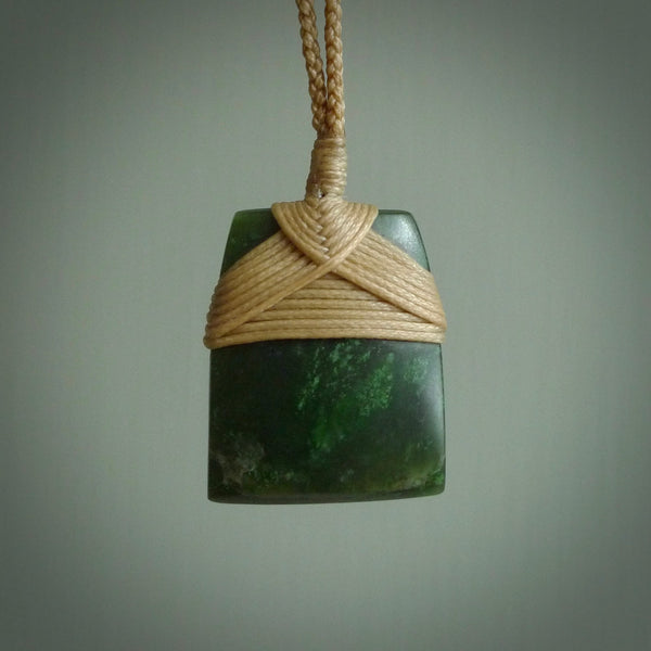 Hand carved from a lovely piece of local New Zealand Jade. The quality of the workmanship and design is outstanding - this is a piece you will want to wear all the time. We have suspended this from a 3-plait tan cord which can be adjusted with a couple of slip knots and tan binding.