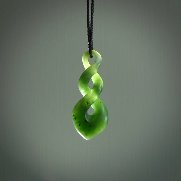This piece is a fine, delicate drop shaped, double twist pendant. It was carved for us by Ric Moor from a lovely deep green piece of New Zealand jade. It is suspended on an black four plaited braided cord that is length adjustable.