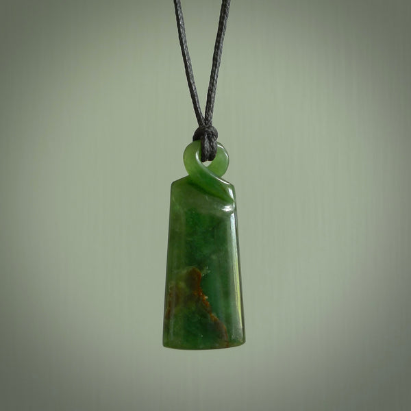 This pendant is a flower jade single twist. It is handcarved from New Zealand flower jade and has a mix of green, mint and pale gold colours interspersed throughout the stone. It has a fine twist, small and light. The cord is hand plaited and can be adjusted. The cord colour on this piece is Khaki. Two sizes available.