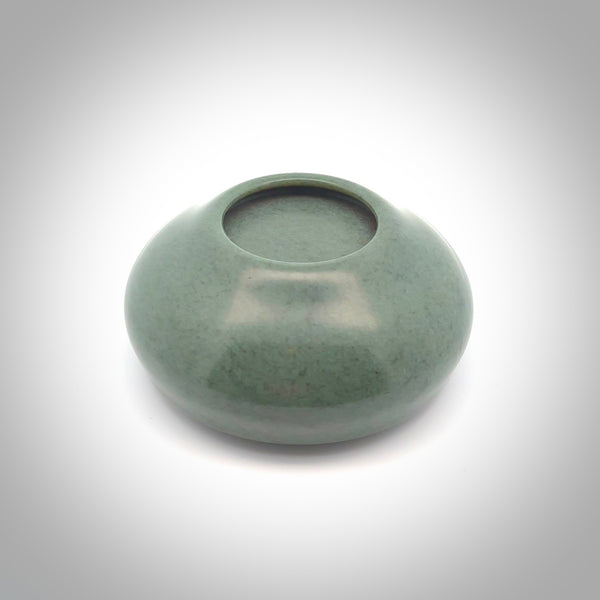 This photo shows a hand carved, Wyoming 'Sage' Nephrite Jade bowl sculpture. This 3.5 inch bowl carved from extremely fine-grained Sage. With Wyoming Black Jade and Sterling Silver, high domed centre grip. This hand crafted work of art was hand made by award winning New Zealand carver Donn Salt.