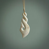 Hand carved stellar intricate twist carving with hook design. A stunning work of art. This pendant was hand carved by Fumio Noguchi, in Bone. A one off collectors item that has been hand crafted to be worn or displayed.