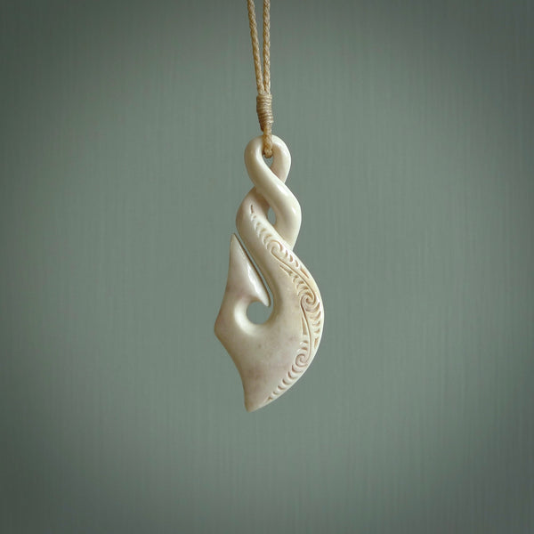 Hand carved stellar intricate twist carving with hook design. A stunning work of art. This pendant was hand carved by Fumio Noguchi, in Bone. A one off collectors item that has been hand crafted to be worn or displayed.