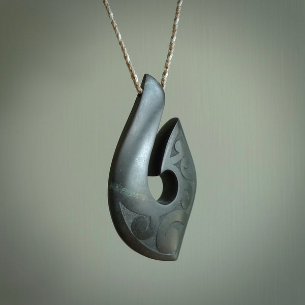 A hand carved large New Zealand Tangiwai Hook, Matau, necklace. The cord is a mushroom and snowstorm grey colour and is length adjustable. A large sized hand made hook necklace by New Zealand artist Rueben Tipene. One off work of art to wear.