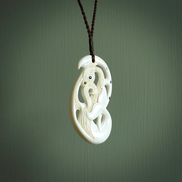 Bone carving of a taniwha. A three dimensional pendant carved in bone by Andrew Doughty. One only taniwha carving for men and women. Provided with an adjustable cord.