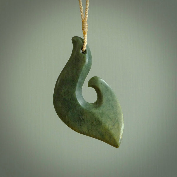 This matau, is a large pendant hand carved from New Zealand jade. It is both intricate and contemporary in design - it has hidden folds and smooth curves. A piece to be worn, the carving and the jade are both magnificent. A large hand carved New Zealand Jade hook by artist Ric Moor.