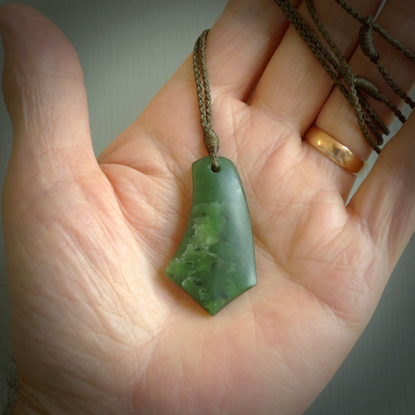 This picture shows a medium sized hand carved jade drop pendant by Ric Moor. The jade is a wonderful deep green. It is suspended from a khaki adjustable cord. Delivery is free worldwide.
