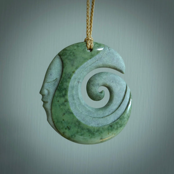 A hand carved koru with face pendant from New Zealand Pounamu, Jade. The cord is Tan and is adjustable. A large hand made Koru necklace by New Zealand artist Kerry Thompson.
