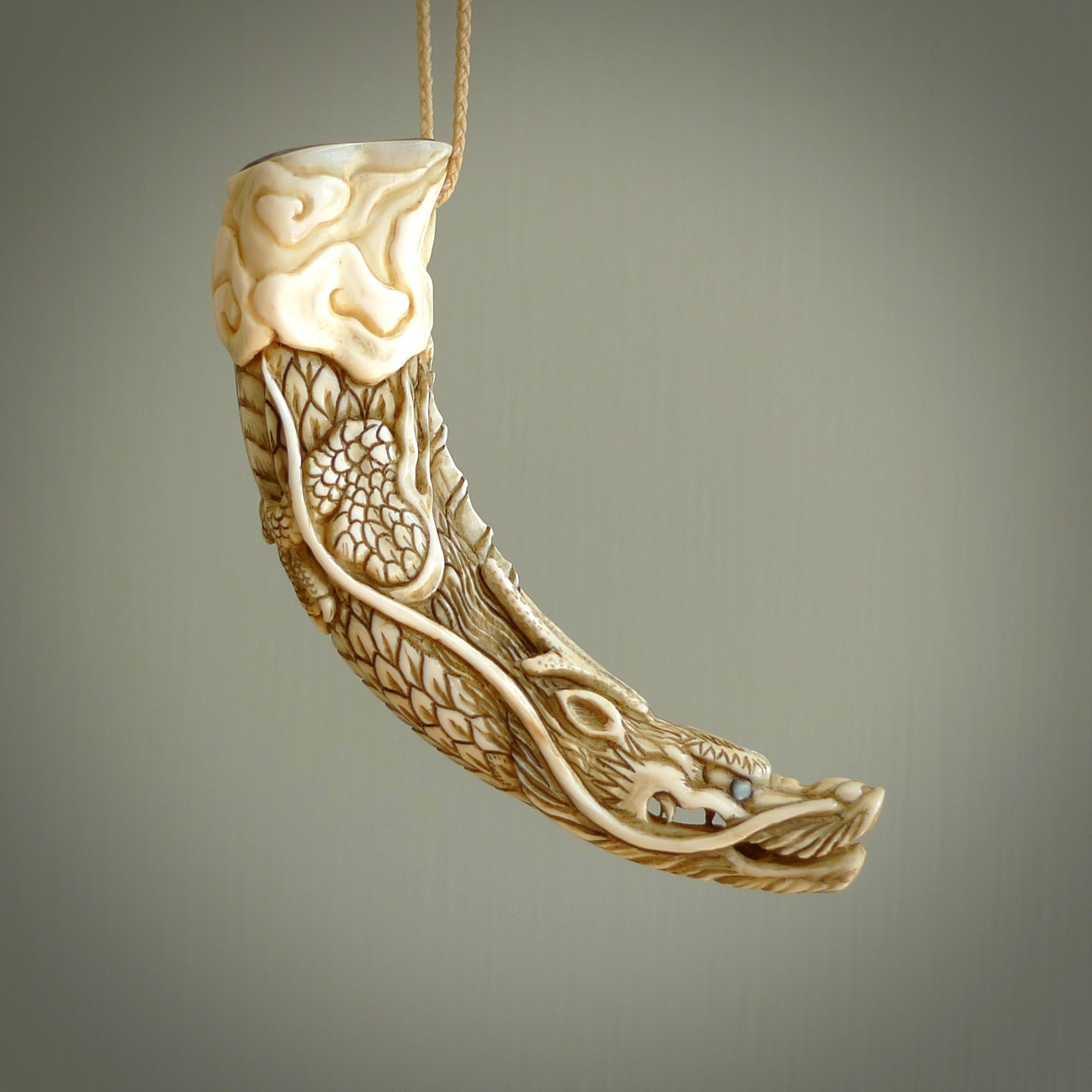Hand carved dragon Pendant. Made from warthog tusk in New Zealand. Unique dragon necklace hand made from warthog tusk by master bone carver Fumio Noguchi. Spectacular collectable work of art, made to wear. One only pendant, delivered to you at no extra cost with express courier.