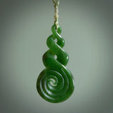 Ross Crump triple twist with koru pendant. Hand carved from rare New Zealand jade this is a beautiful pounamu pendant. The cord is hand plaited in green and white colours and is length adjustable. It has a floret in white. It is a delicate and very beautiful greenstone pendant. For sale online by NZ Pacific.