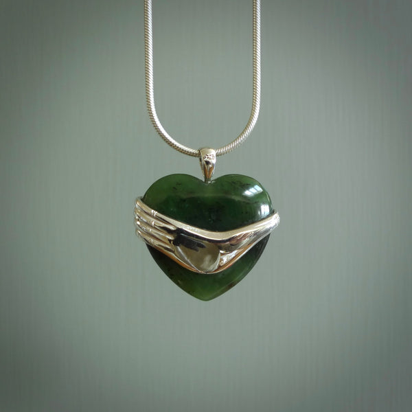 Hand crafted New Zealand jade heart in sterling silver hand necklace. This piece has a sterling silver hand holding a Jade heart. This necklace is provided with a sterling silver chain.