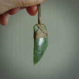 Hand carved from a lovely piece of local New Zealand Jade. The quality of the workmanship and design is outstanding - this is a piece you will want to wear all the time. We have suspended this from a 4-plait olive cord which can be adjusted with a couple of slip knots and olive binding.