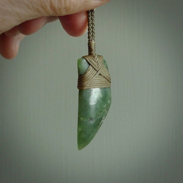Hand carved from a lovely piece of local New Zealand Jade. The quality of the workmanship and design is outstanding - this is a piece you will want to wear all the time. We have suspended this from a 4-plait olive cord which can be adjusted with a couple of slip knots and olive binding.