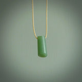 This picture shows a small hand carved jade drop pendant by Ric Moor. The jade is a wonderful light, semi-translucent, green. It is suspended from a beige adjustable cord. Delivery is free worldwide.