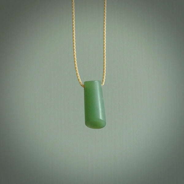 This picture shows a small hand carved jade drop pendant by Ric Moor. The jade is a wonderful light, semi-translucent, green. It is suspended from a beige adjustable cord. Delivery is free worldwide.