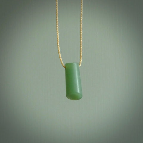 This picture shows a small hand carved jade drop pendant by Ric Moor. The jade is a wonderful light, semi-translucent, green. It is suspended from a beige adjustable cord. Delivery is free worldwide.