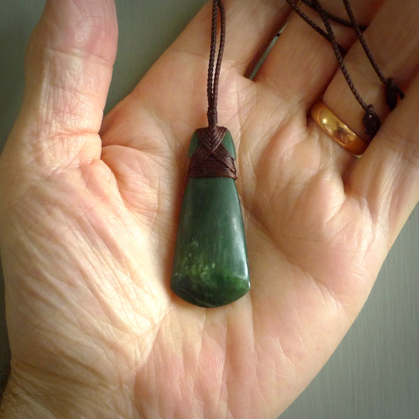 Hand carved from a lovely piece of local New Zealand Jade. The quality of the workmanship and design is outstanding - this is a piece you will want to wear all the time. We have suspended this from a 3-plait brown cord which can be adjusted with a couple of slip knots and brown binding.