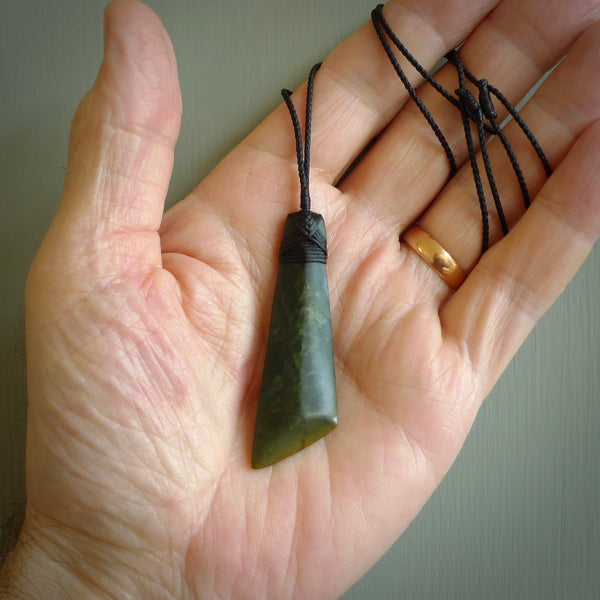 Hand carved from a lovely piece of local New Zealand flower Jade. The quality of the workmanship and design is outstanding - this is a piece you will want to wear all the time. We have suspended this from a 3-plait black cord which can be adjusted with a couple of slip knots and black binding.