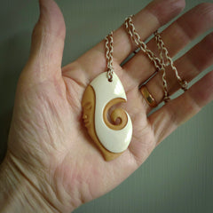 A hand carved bone contemporary, intricate pendant. The cord is ice white/gingernut and is an adjustable length. A large sized hand made contemporary necklace by New Zealand artist Kerry Thompson. Kerry has stained parts of the bone which really add to the dimension of this pendant. One off work of art to wear.