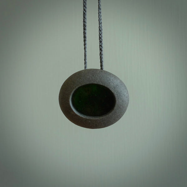 A drop pendant made from Onewa Stone - New Zealand Greywacke - with a fine green antique window glass insert spliced into the middle.