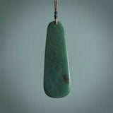This photo shows a large jade drop shaped pendant. It a a lovely, colourful Inanga jade. The cord is a four plait green and tan colour and is adjustable in length. One only large, contemporary drop necklace from Jade, by Rueben Tipene.