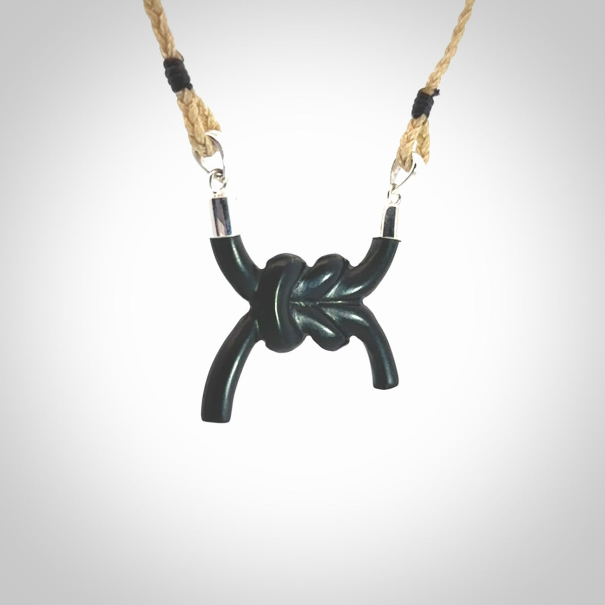A gorgeous hand carved black jade reef knot pendant with sterling silver. Hand made in Black Jade with Sterling Silver and provided with adjustable cord.
