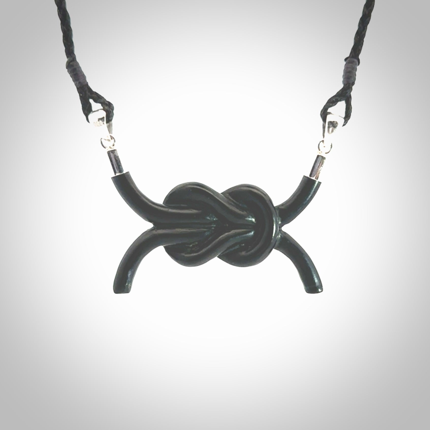 A gorgeous hand carved black jade reef knot pendant with sterling silver. Hand made in Black Jade with Sterling Silver and provided with adjustable cord.