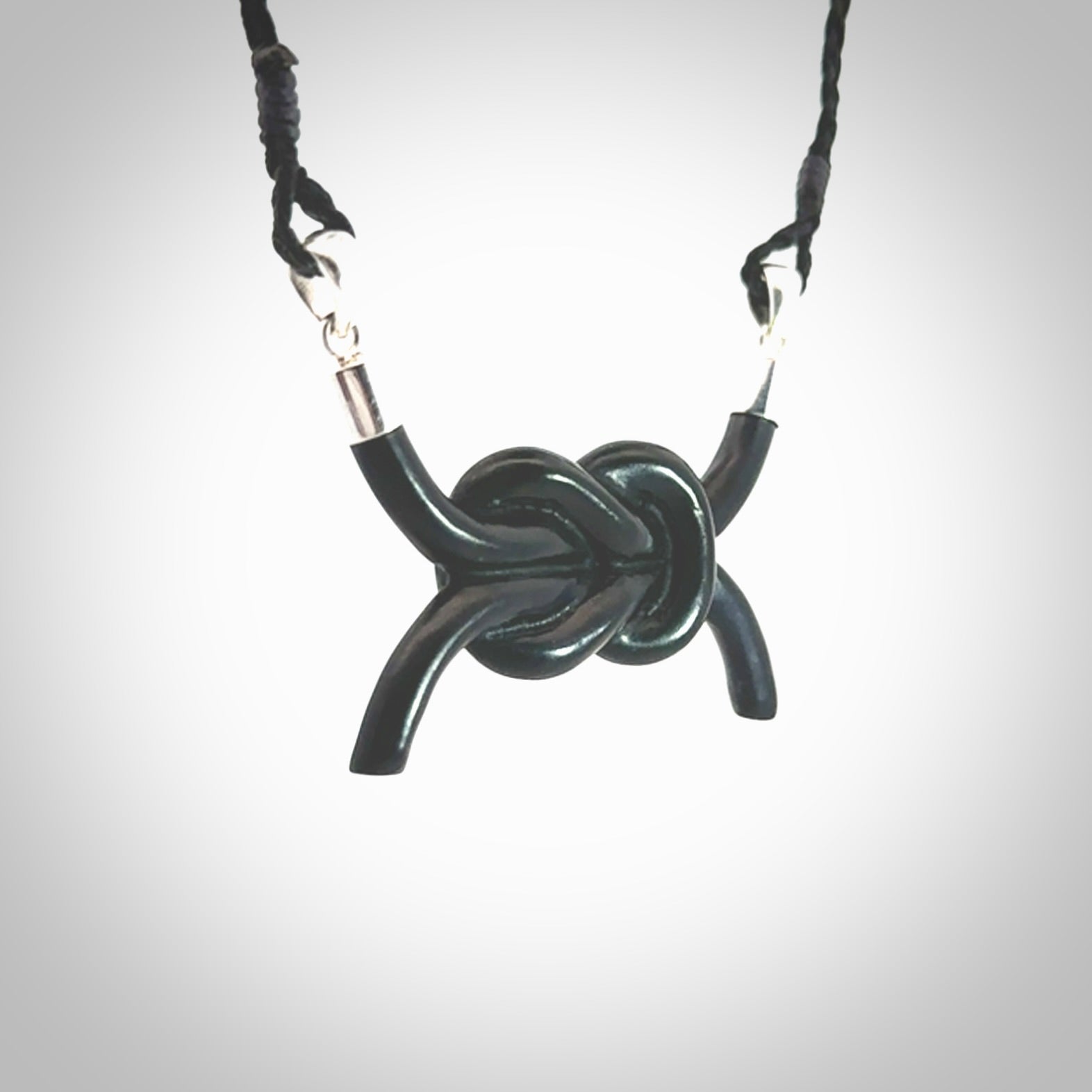 A gorgeous hand carved black jade reef knot pendant with sterling silver. Hand made in Black Jade with Sterling Silver and provided with adjustable cord.