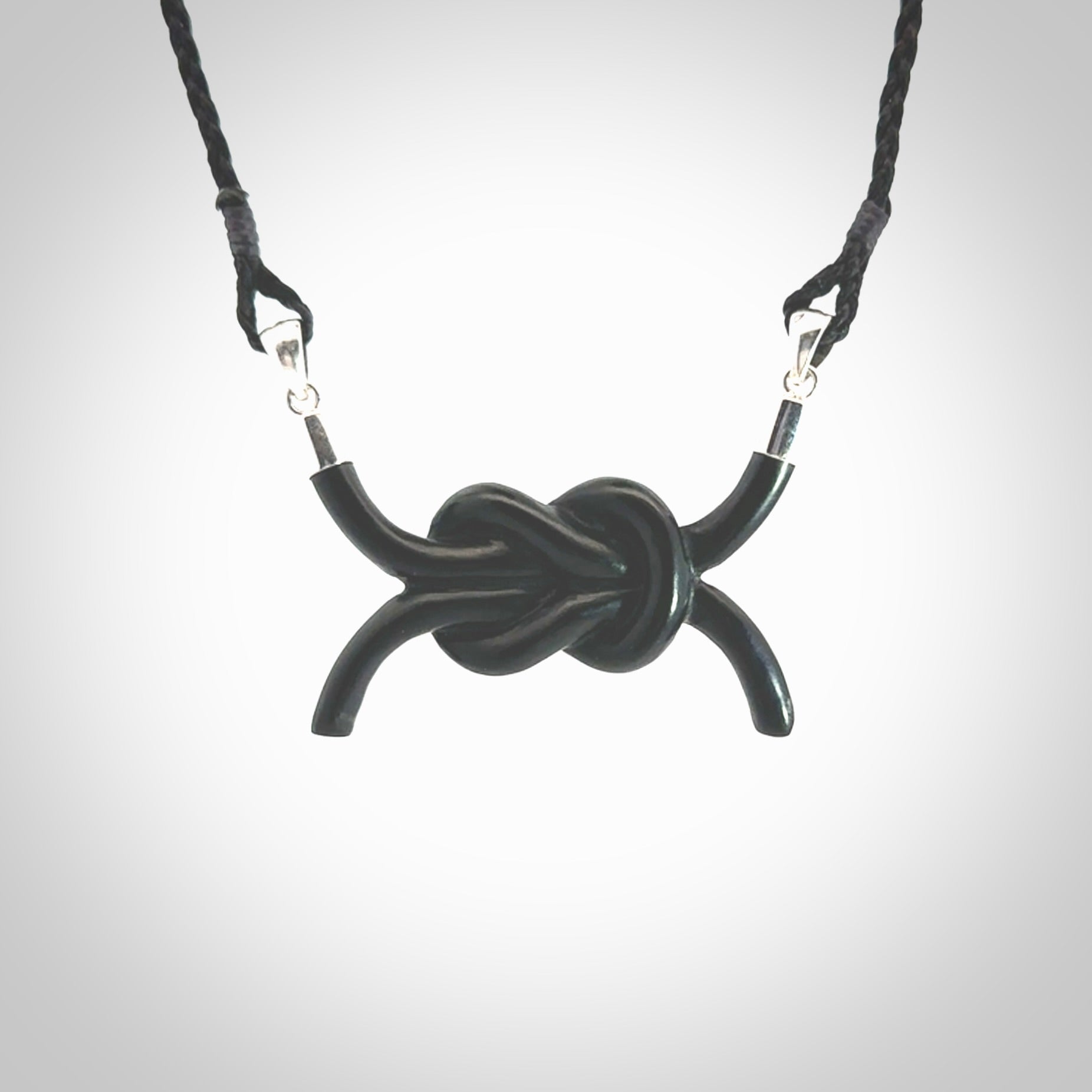 A gorgeous hand carved black jade reef knot pendant with sterling silver. Hand made in Black Jade with Sterling Silver and provided with adjustable cord.