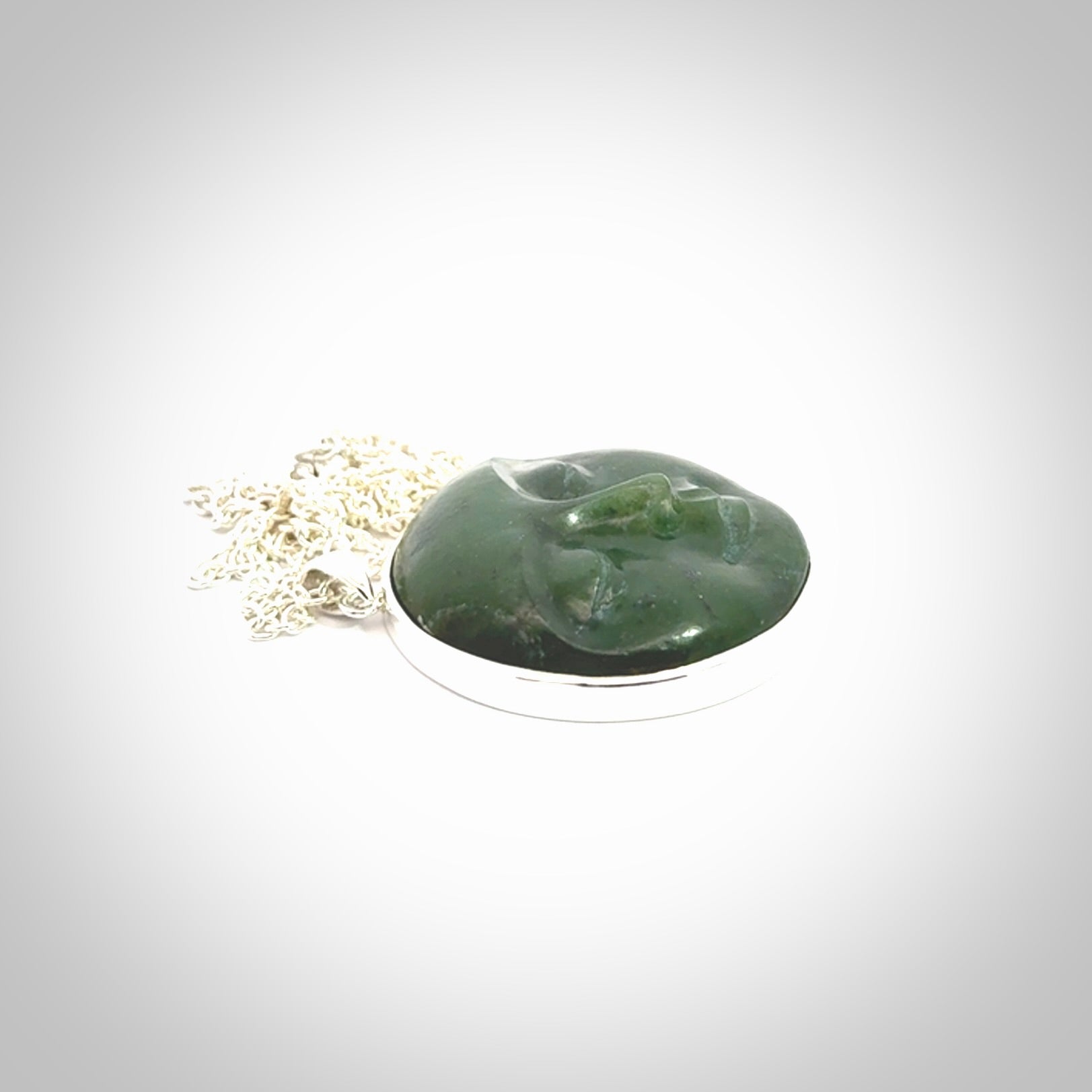 Hand made New Zealand Jade moon face necklace with Sterling Silver. Made by NZ Pacific and sale online only. Delivered with sterling silver chain and packaged in a woven kete pouch.