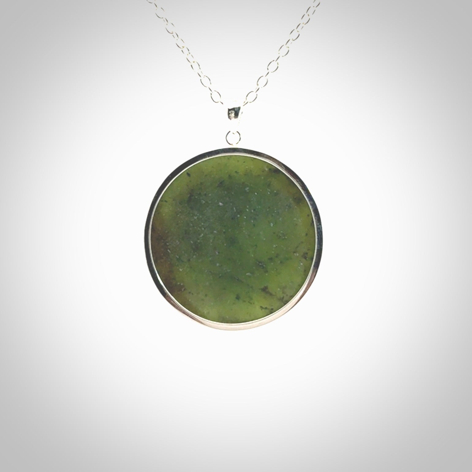 Hand made New Zealand Jade moon face necklace with Sterling Silver. Made by NZ Pacific and sale online only. Delivered with sterling silver chain and packaged in a woven kete pouch.