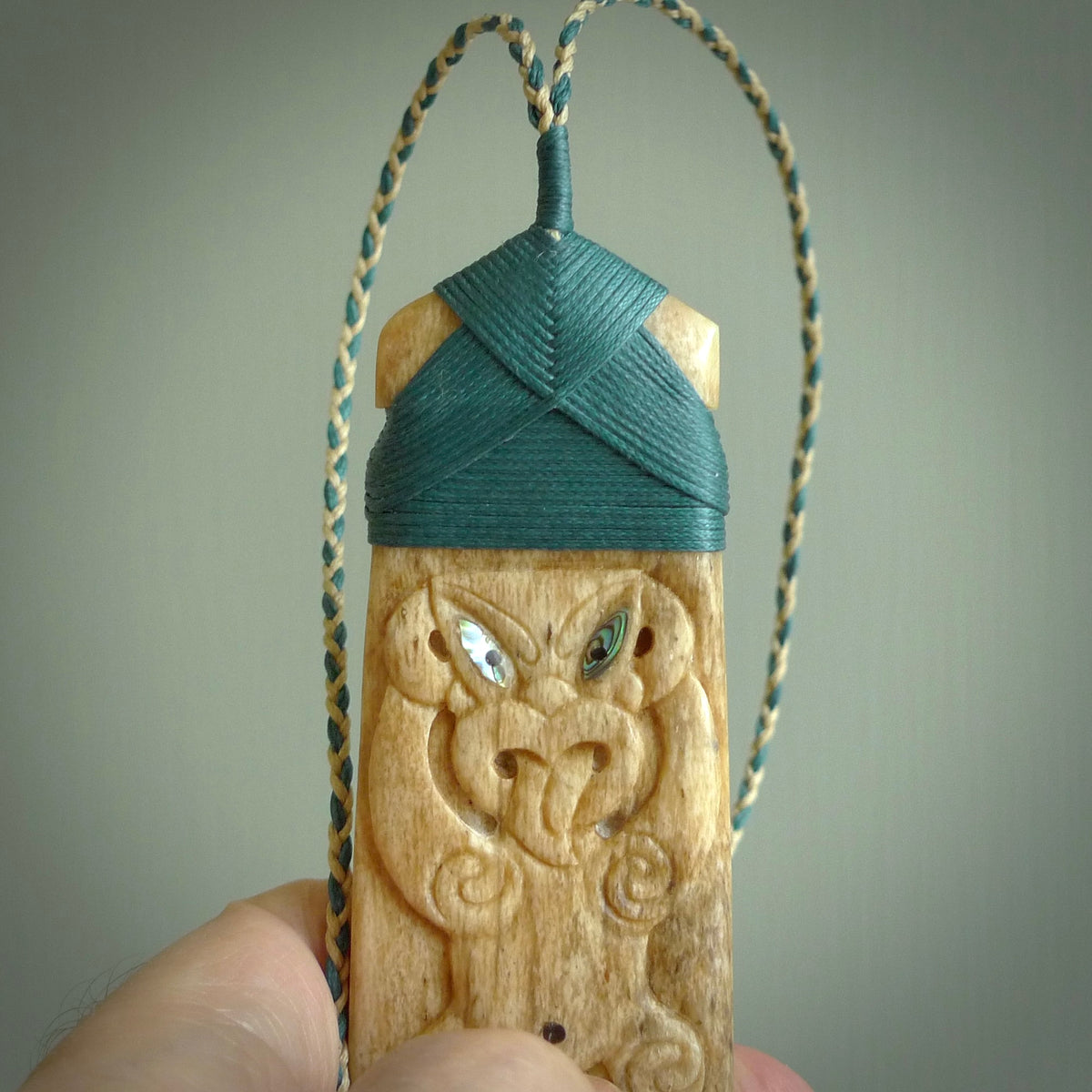 HAND CARVED BONE TOKI WITH TIKI PENDANT. BONE TOKI WITH TIKI PENDANT