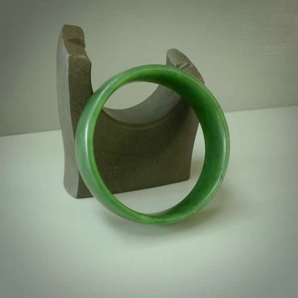 Hand carved jade bangle. Carved from green New Zealand jade. This is a solid jade bangle carved from a single piece of jade. It is polished to a sleek matte. the jade is otherwise untreated and completely natural.