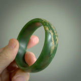 Hand carved jade bangle. Carved from green New Zealand jade. This is a solid jade bangle carved from a single piece of jade. It is polished to a sleek matte. the jade is otherwise untreated and completely natural.