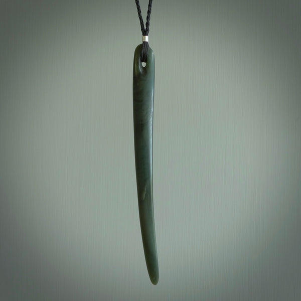 This picture shows a hand carved Pounamu jade beak drop pendant with adjustable cord. The jade is a very dark green with shimmering blue tones in the stone. It is suspended from a adjustable cord. Delivery is free worldwide.