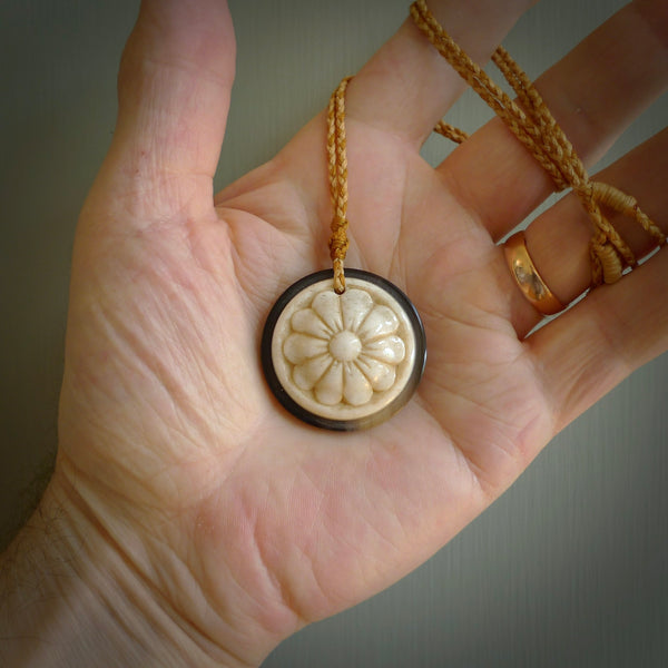 Hand carved natural bone with buffalo horn contemporary disc pendant with creative and unique carvings on the front face of each individual piece. Delivered with an adjustable cord.
