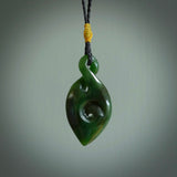 Ross Crump twist with koru pendant. Hand carved from rare New Zealand jade this is a beautiful pounamu pendant. The cord is hand plaited and is length adjustable. It has a little spiral floret popper at the top of the pendant. It is a delicate and very beautiful greenstone pendant. For sale online by NZ Pacific.