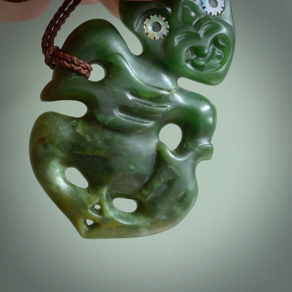 This is a large sized tiki - carved from gorgeous Marsden jade with Pāua Shell eyes. The craftsmanship is superb, this piece is as well carved as any we have seen. We have plaited an adjustable brown cord for this piece. 