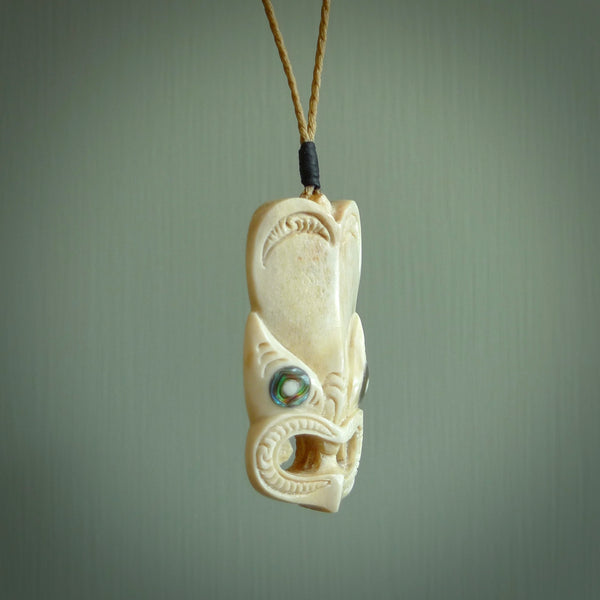 Hand carved incredible Deer Antler  wheku face carving. A stunning work of art. This pendant was hand carved in Deer Antler with Paua Shell inlay for the eyes. Shipping is included in the price. Delivered to you on an adjustable cord.