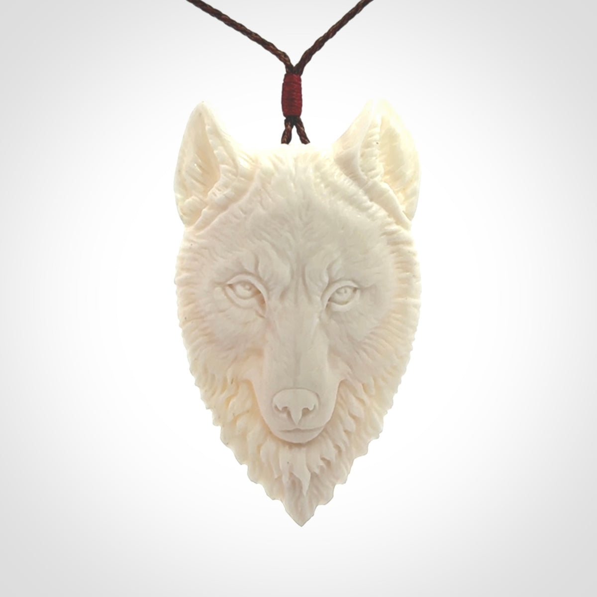 Hand carved bone wolf pendant.