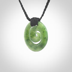 Hand carved British Columbian jade koru pendant. Delivered to you on a hand plaited black cord which is adjustable. Free delivery worldwide.