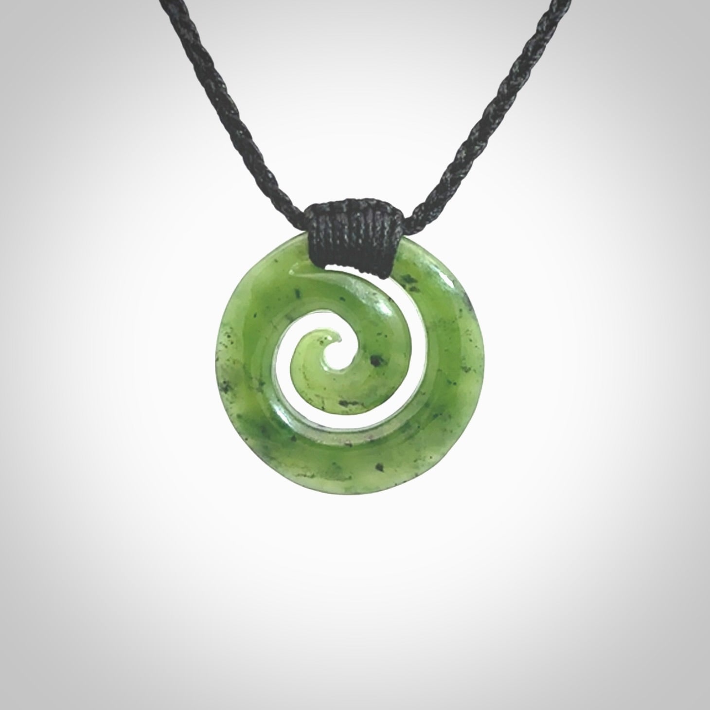 Hand carved British Columbian jade koru pendant. Delivered to you on a hand plaited black cord which is adjustable. Free delivery worldwide.