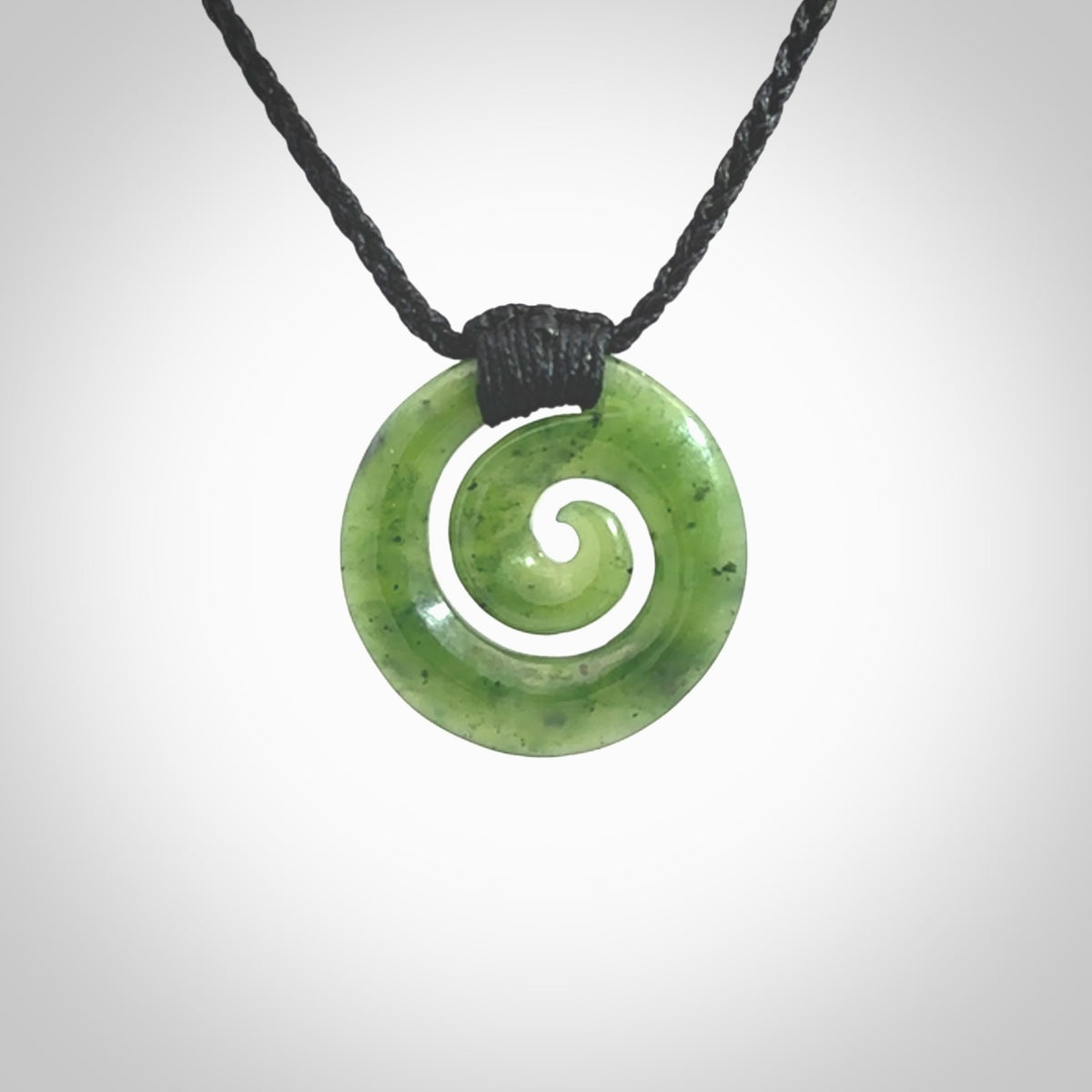 Hand carved British Columbian jade koru pendant. Delivered to you on a hand plaited black cord which is adjustable. Free delivery worldwide.