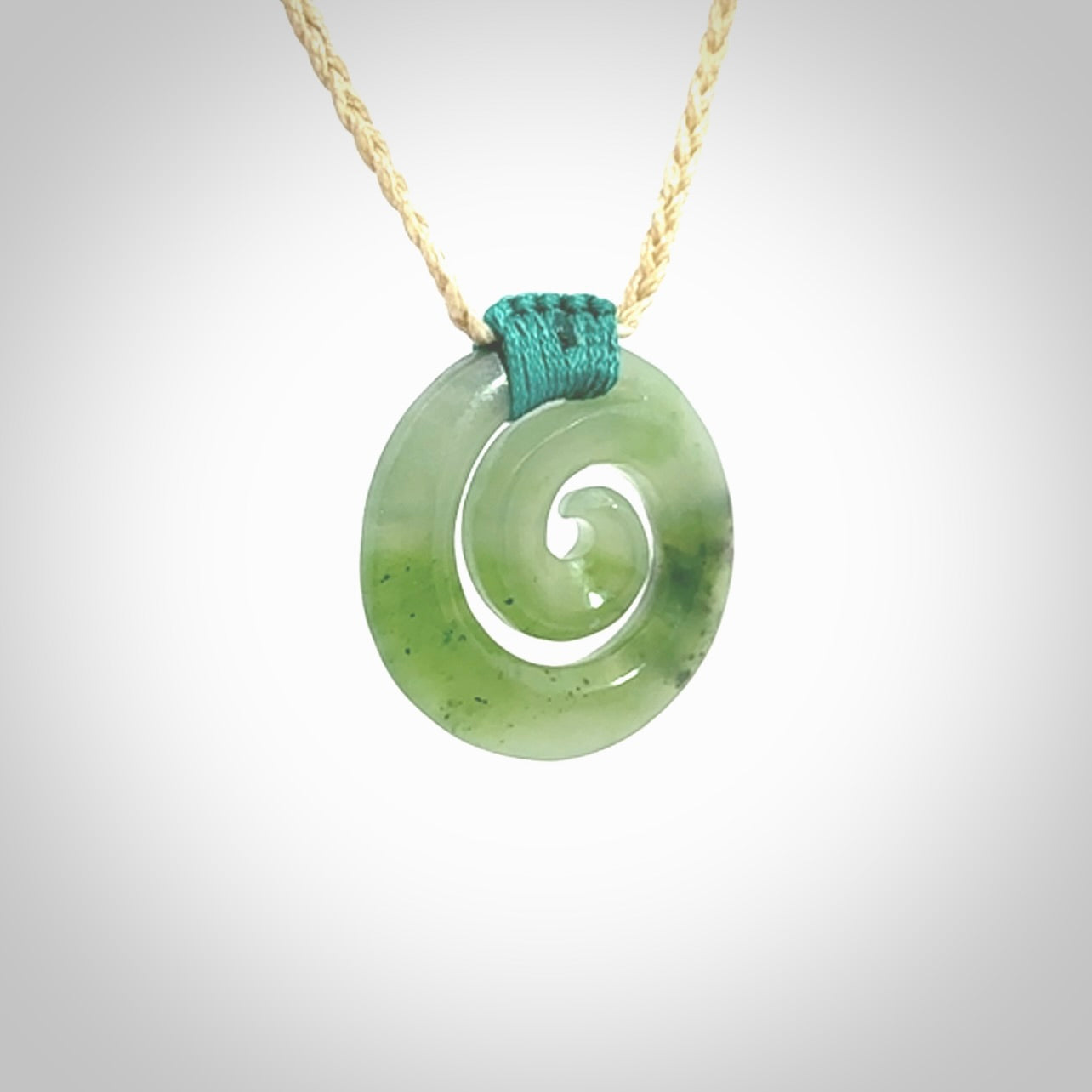 Hand carved British Columbian jade koru pendant. Delivered to you on a hand plaited oat coloured cord which is adjustable. Free delivery worldwide.