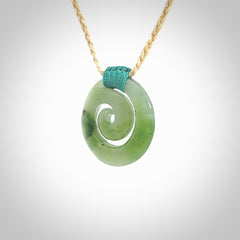 Hand carved British Columbian jade koru pendant. Delivered to you on a hand plaited oat coloured cord which is adjustable. Free delivery worldwide.
