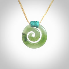 Hand carved British Columbian jade koru pendant. Delivered to you on a hand plaited oat coloured cord which is adjustable. Free delivery worldwide.