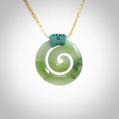 Hand carved British Columbian jade koru pendant. Delivered to you on a hand plaited oat coloured cord which is adjustable. Free delivery worldwide.