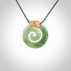 Hand carved British Columbian jade koru pendant. Delivered to you on a hand plaited manuka green cord which is adjustable. Free delivery worldwide.