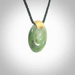Hand carved British Columbian jade koru pendant. Delivered to you on a hand plaited manuka green cord which is adjustable. Free delivery worldwide.
