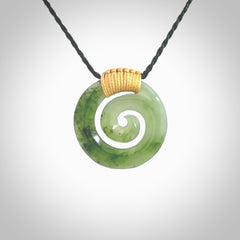 Hand carved British Columbian jade koru pendant. Delivered to you on a hand plaited manuka green cord which is adjustable. Free delivery worldwide.